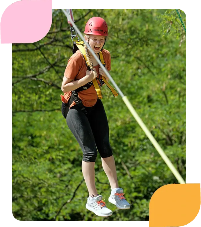 Girl going down zip wire on adventure holiday in Ardeche, France.